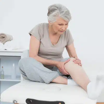 Elderly woman experiences pain after total joint replacement and evaluates her recovery progress