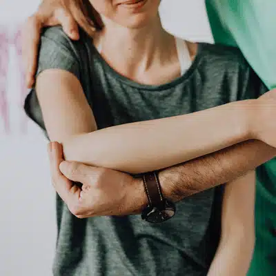healthcare provider supporting a patient’s arm during a manual shoulder assessment for an orthopedic shoulder surgeon referral