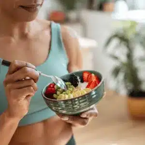 Woman eats healthy bowl, showing diet's role in effective shoulder surgery recovery tips and healing