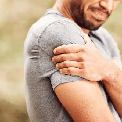 Man grips sore shoulder, wondering how do i know if i need shoulder surgery soon
