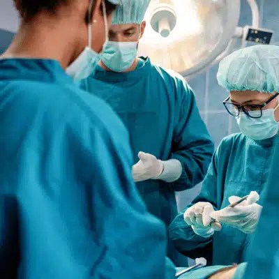 Surgeons preparing in operating room to perform outpatient hip replacement on patient