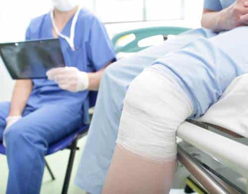Patient with a bandaged knee consulting an orthopedic specialist
